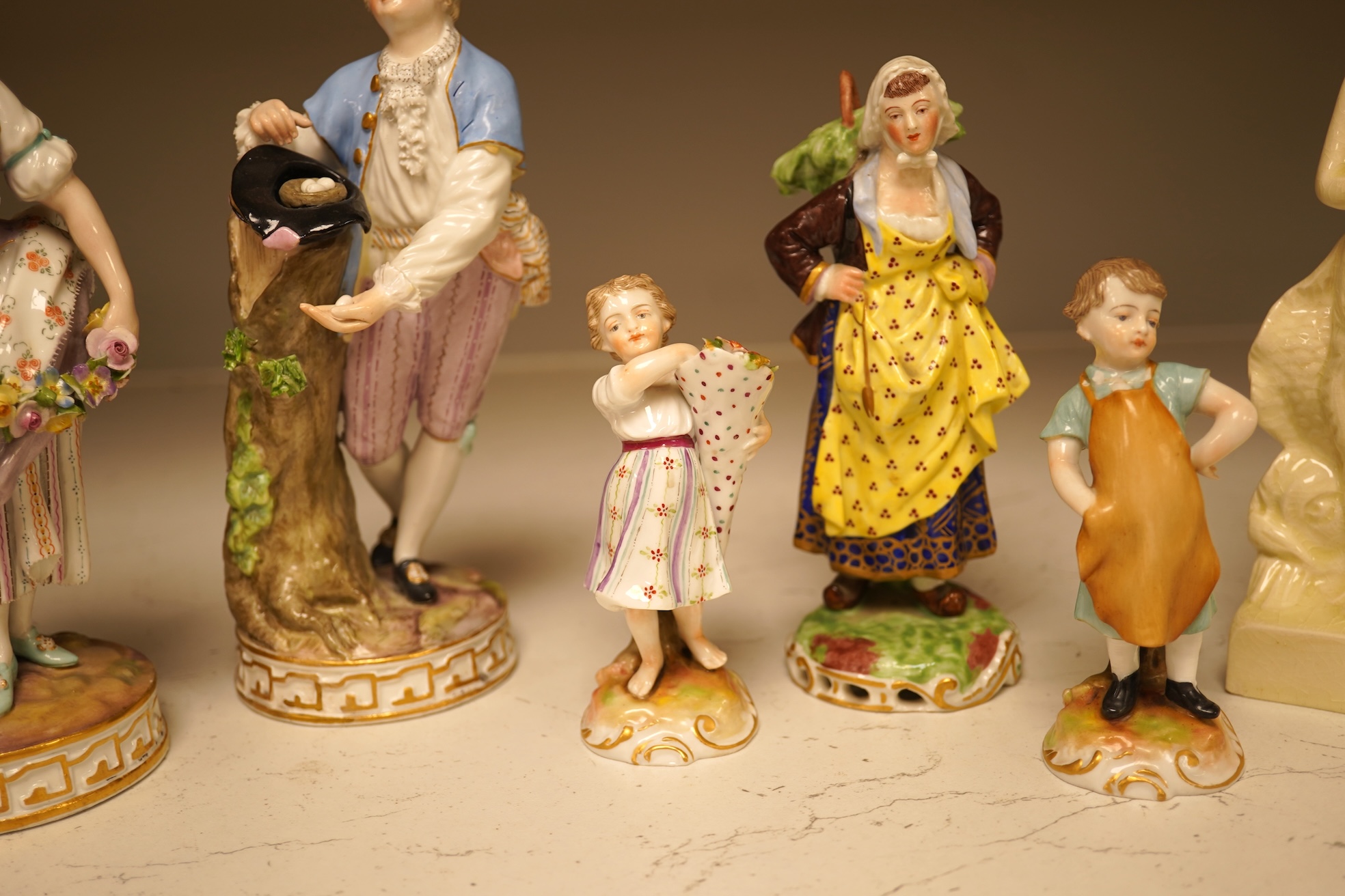 A pair of 19th century Meissen figurines, a Crown Derby figure, a pair of miniature figures and a Leeds type creamware group of Venus and Cupid, tallest 18cm high.